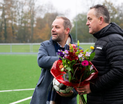 Van der Zwan l feliciteert voorzitter Gijs Lokhorst r met het nieuwe kunstgrasveld